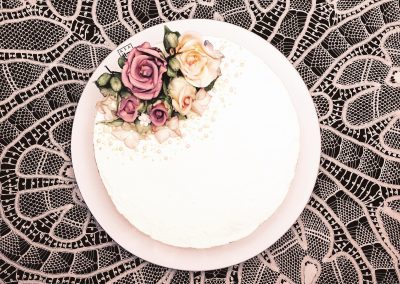 Rosas de açúcar na decoração desse bolo de aniversário. Na massa e na cobertura foi usada água de rosas