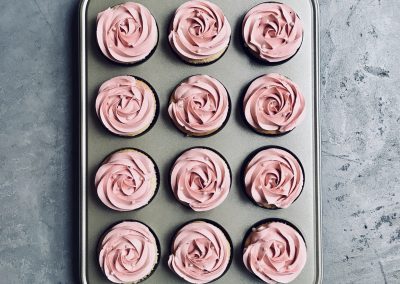 Cupcakes de chocolate branco e rosas cobertos por creme de manteiga italiano com essência de rosas